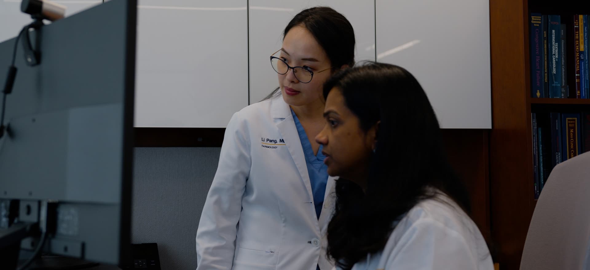 Two WVU Medicine cardiologists in white coats reviewing results at a workstation